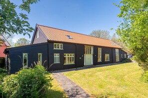 A two-story house with a red-tiled roof, a front door, and a small window on the upper floor. - Wolmers Barn, Stonham Aspal, Suffolk (Stonham Aspal)