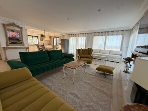A living room with a green sofa, yellow armchair, and a coffee table. - Villa Bel Azur: Panoramic View of the Sea and the Golf Course (Tabarka)