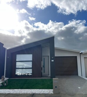 A modern two-story house with a large garage door, a visible garage door number '28', and a well-maintained lawn. - Modern 4BR Family Home in Wollert, VIC (Wollert)