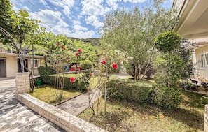 Ein Innenhof mit Garten, einem Weg und einem Gebäude mit Balkon.