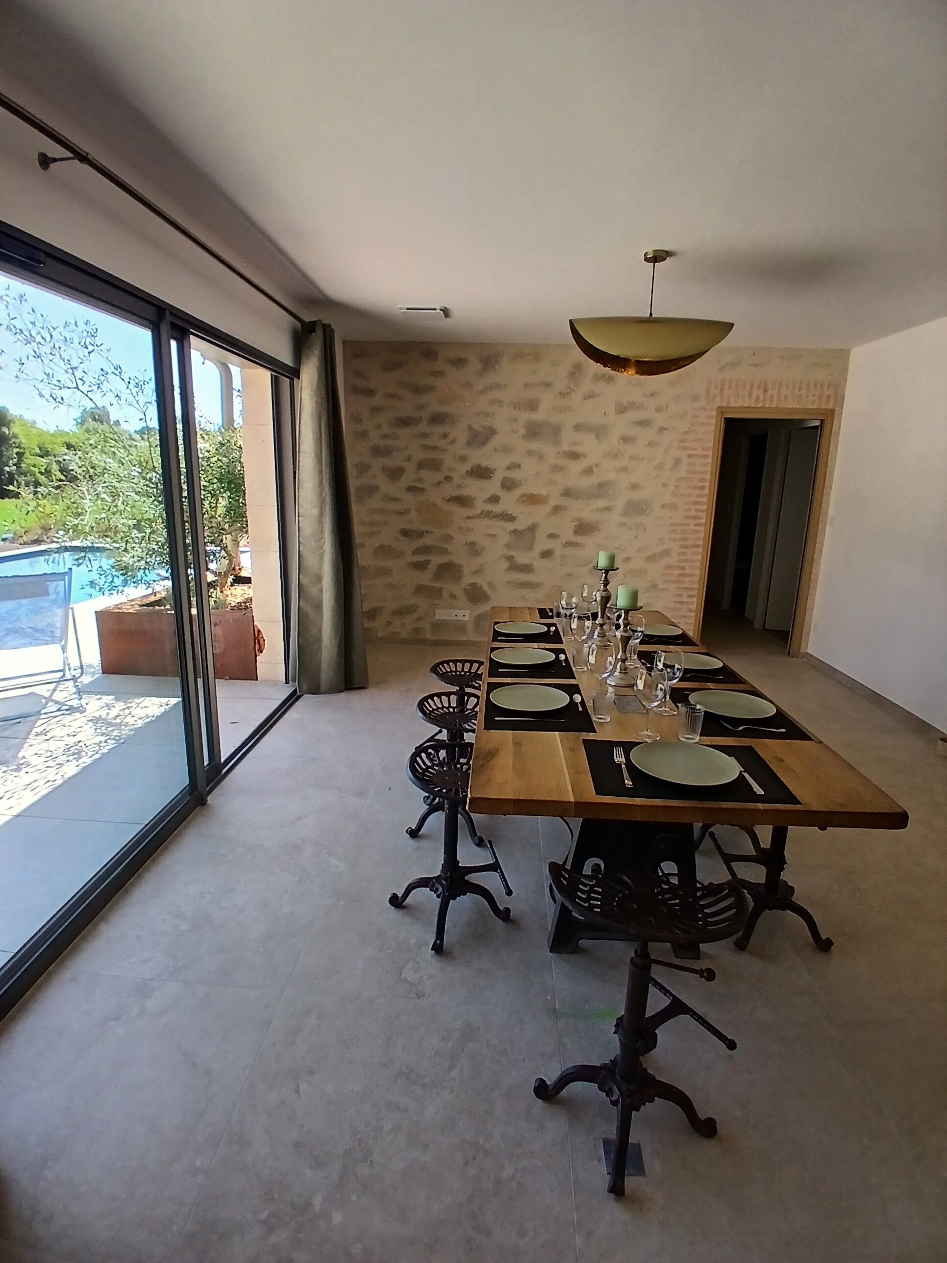 A dining room with a long table, chairs, and a view of the outdoors.
