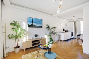 Ein modernes Wohnzimmer mit Essbereich, einer Küche und einem großen Fenster.