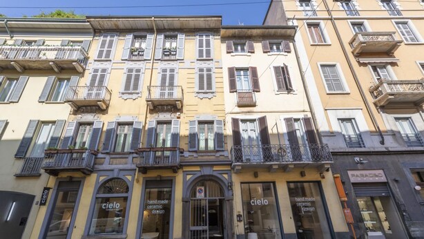 Une rangée d’immeubles à étages, dotés de devantures de magasins, parmi lesquels on trouve une boutique de design en céramique appelée « Cielo ».