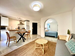 Espaço compacto com cozinha, área de refeições e quarto.