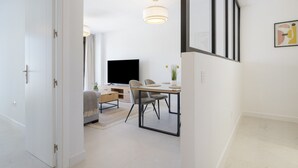 Una sala de estar moderna con televisor, mesa de comedor y sillas.