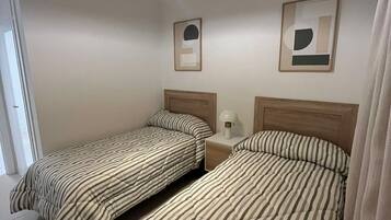 Tabla de planchar con plancha, wifi y ropa de cama