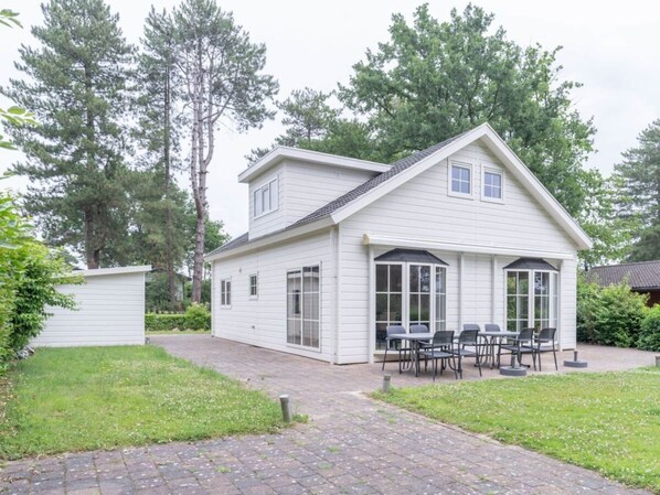 A white two-story house with a covered patio and outdoor seating area. - Hackfort L"etage 8 (Brunssum)
