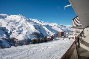 A snow-covered mountain with a building and a wooden structure in the foreground.