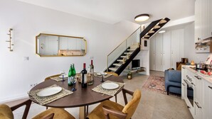 A dining area with a round table, chairs, and a mirror on the wall.