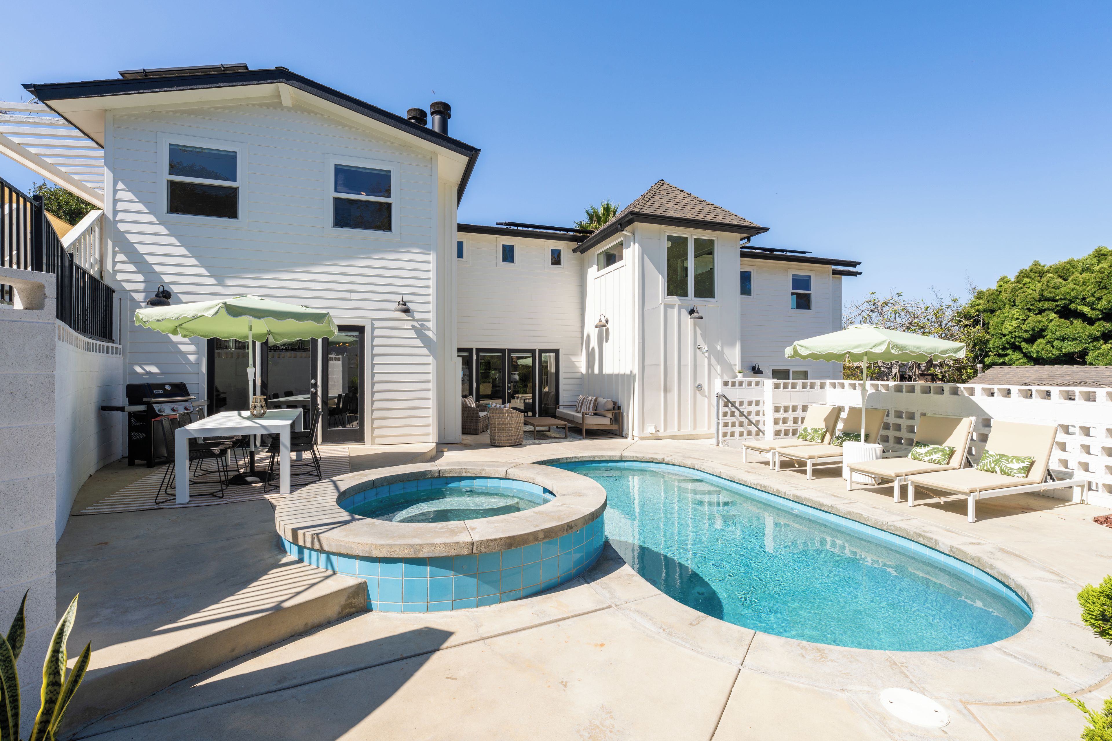 A residential property with a swimming pool, outdoor furniture, and a barbecue area.
