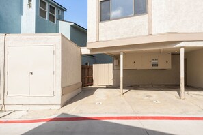 A building with a covered outdoor area, a door, and a 'TOW AWAY' sign. - Ground Floor Waterfront | AC | Private Patio (San Diego)