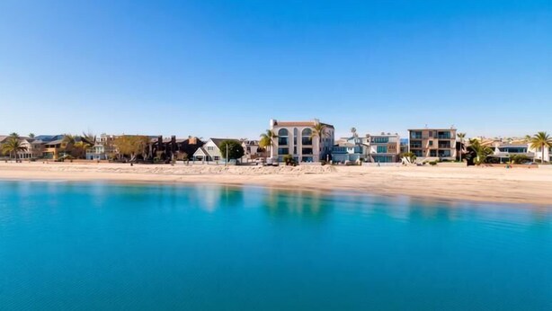 Un hotel frente al mar con vista a la costa, varios pisos y una zona de piscina.