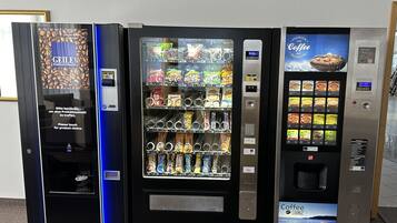 Tres máquinas expendedoras con diversas opciones de comida y bebida.