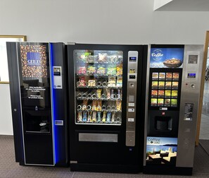 Three vending machines with various snack and beverage options. - City Best Autobahnhotel Stolper Heide (Hohen Neuendorf)