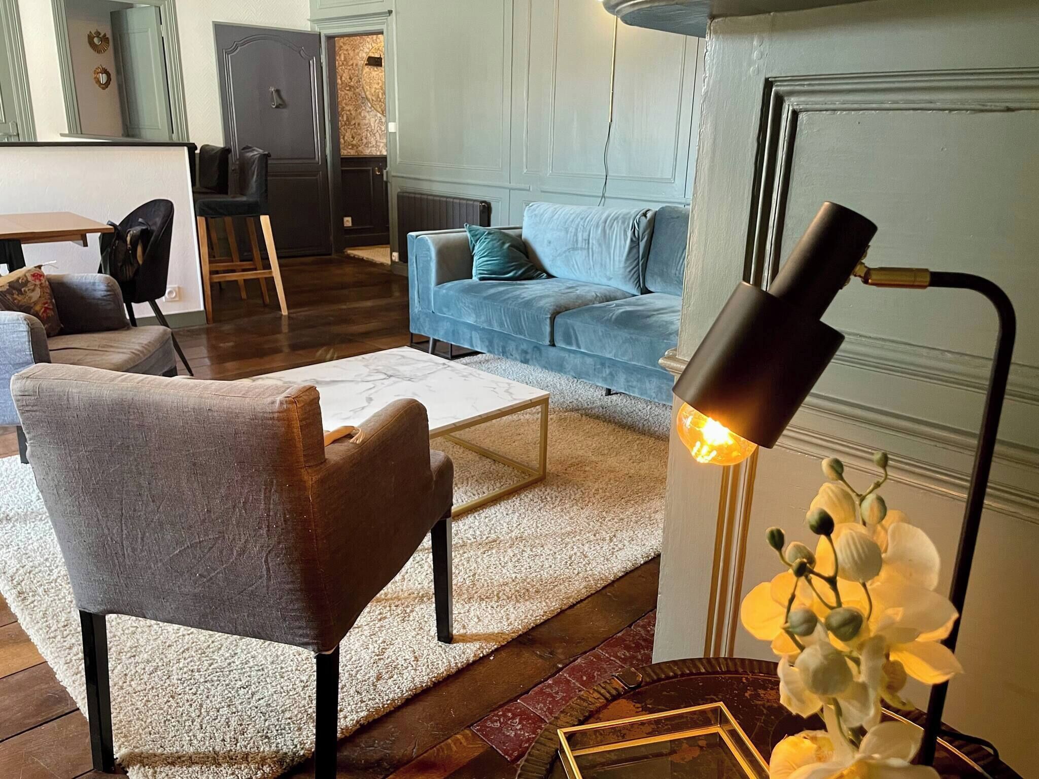 Una sala de estar moderna con sofá, sillón, mesa de centro y lámpara de pie.