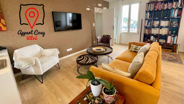 A living room with a sofa, armchair, coffee table, TV, bookshelf, and a wall-mounted location pin.