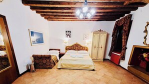 A bedroom with a bed, a wardrobe, a mirror, and a chandelier. - Room-venezia Baroque Charm (Venice)