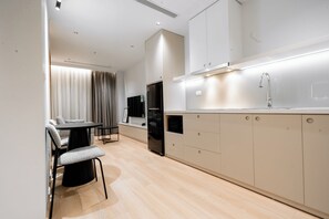 Una cocina moderna con comedor, armarios empotrados y un refrigerador negro.