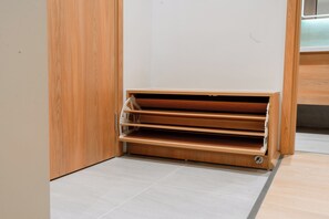A corner of a room with a wooden cabinet and a built-in shelf unit. - Hapu Hotel - Apartment (Cua Nam)