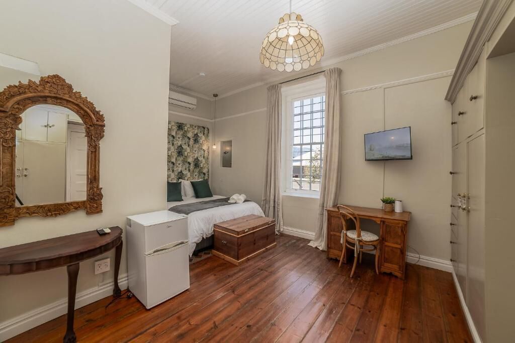 Een slaapkamer met een bed, een dressoir, een kaptafel en een televisie.