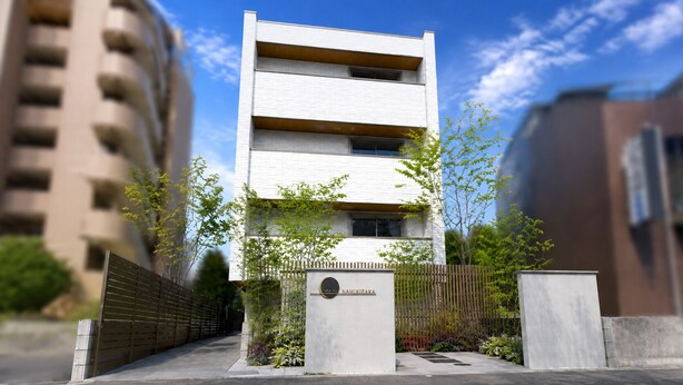 Um edifício moderno com fachada branca, placa de identificação e entrada protegida por grades.