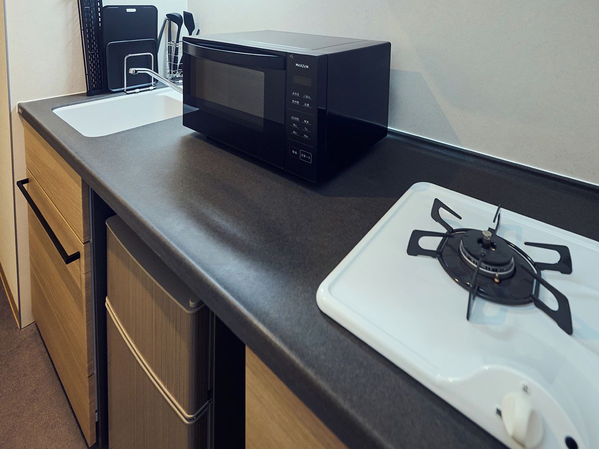 Een keuken met een magnetron en een gasfornuis.