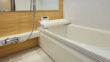 A modern bathroom with a white bathtub, a wooden vanity, and a mirror above the sink.