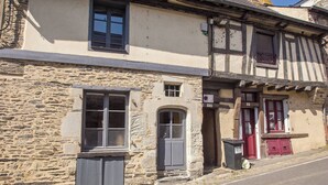 A stone building with a window, a door, and a small balcony.