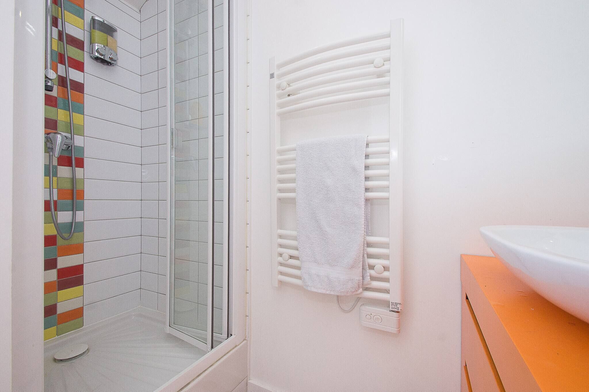Ein Badezimmer mit Dusche, Handtuchhalter und Waschbecken.