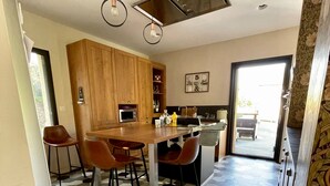 A modern kitchen with a central island, hexagonal patterned floor, and pendant lighting. - Riverside House with Jacuzzi (Vitré)