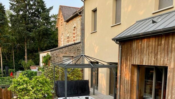 A deck with outdoor furniture, a hot tub, and a covered area. - Riverside House with Jacuzzi (Vitré)