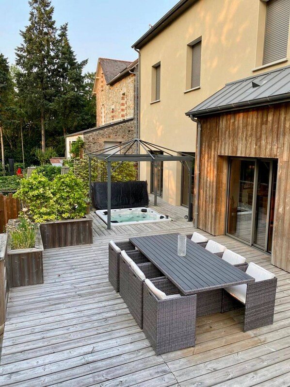 A deck with outdoor furniture, a hot tub, and a covered area. - Riverside House with Jacuzzi (Vitré)