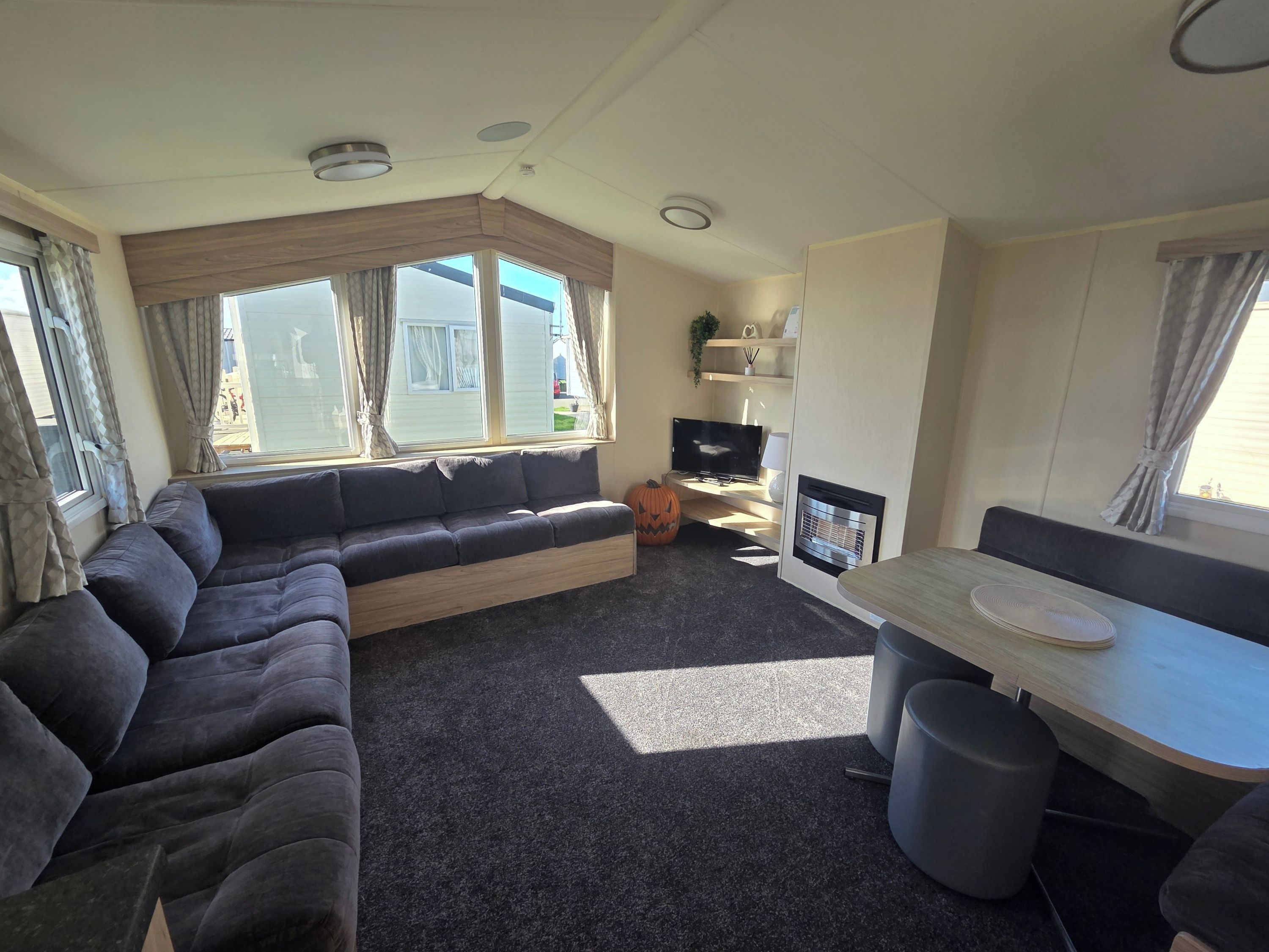 A compact living space with a sofa, a small table, a television, and a fireplace.