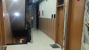 Un pasillo con suelo de baldosas, puertas de madera y pared estampada.