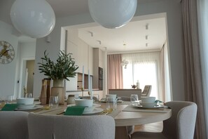 Un coin repas avec une table ronde, des chaises et une plante servant de décoration centrale.