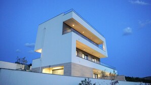 A modern multi-story building with balconies and large windows. - Villa Bella Vista with heated pool (Rovanjska)
