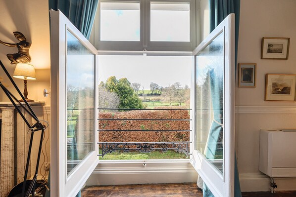 Ein Zimmer mit großem Fenster, Heizkörper und Lampe.