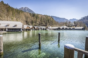 Ein Hotel am See mit klarem Wasser, Holzstegen und Blick auf die Berge.