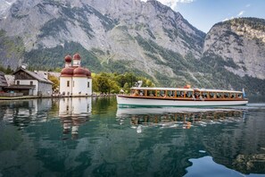 A boat on a calm lake with a mountain backdrop. - Stylish "Alpenchic" Apartment in a Prime Location on Lake Königssee (Schönau am Königssee)