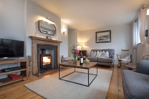 A cozy living room with a fireplace, a television, and comfortable seating. - Chantry Cottage (4) - sleeps 4 guests  in 2 bedrooms, Beaminster, Dorset (Chard, Beaminster)