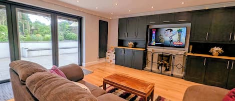 A modern living room with a sofa, a coffee table, and a TV.