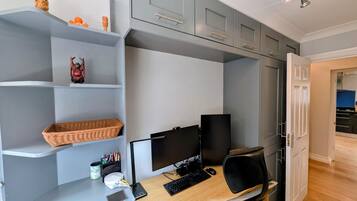 Un espacio de oficina moderno con escritorio, computadora y estanterías.