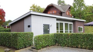 A modern two-story house with a flat roof, large windows, and a gravel driveway. - Holiday Home in Brunssum With Terrace (Brunssum)