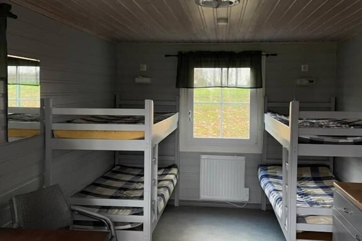 Ett rum med våningssängar, ett bord och ett fönster med utsikt.
