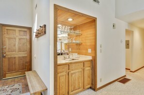 Ein Holzinnenraum mit Küchenbereich, inklusive Arbeitsplatte, Spüle und einer Glasvitrine.