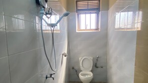 Un baño pequeño con inodoro, ducha y ventana.