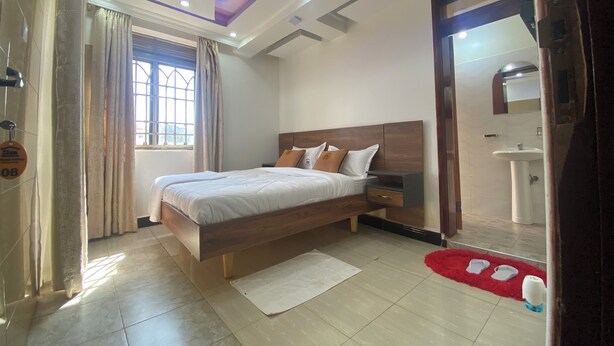 Un dormitorio moderno con una cama de madera, una mesita de noche, un espejo, una ventana con cortinas y una alfombra roja.