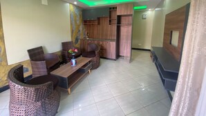Una sala de estar moderna con comedor, cocina y televisor.