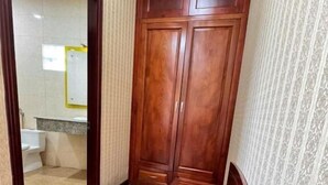 A hallway with a wooden bench, a wardrobe, and a patterned wall.