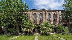 Un edificio histórico con fachada de ladrillo, ventanas de arco y una entrada central.